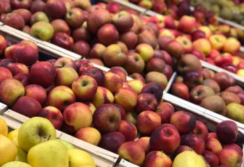 Présentoir de pommes fraîches jaunes et rouges au Marché Pernoud, idéales pour des recettes de saison simples et savoureuses.