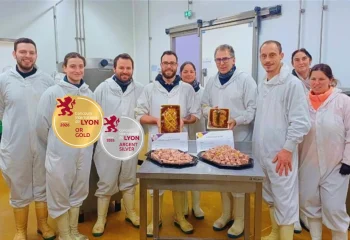 Atelier de production charcutière avec des collaborateurs Marché Pernoud brandissant 2 terrines médaillées or et argent
