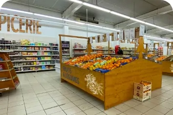 Intérieur du magasin du Marché Pernoud à Anthy-sur-Léman, avec des étals de fruits et légumes frais et des rayons d'épicerie, marquant l'ouverture d'un nouveau point de vente.